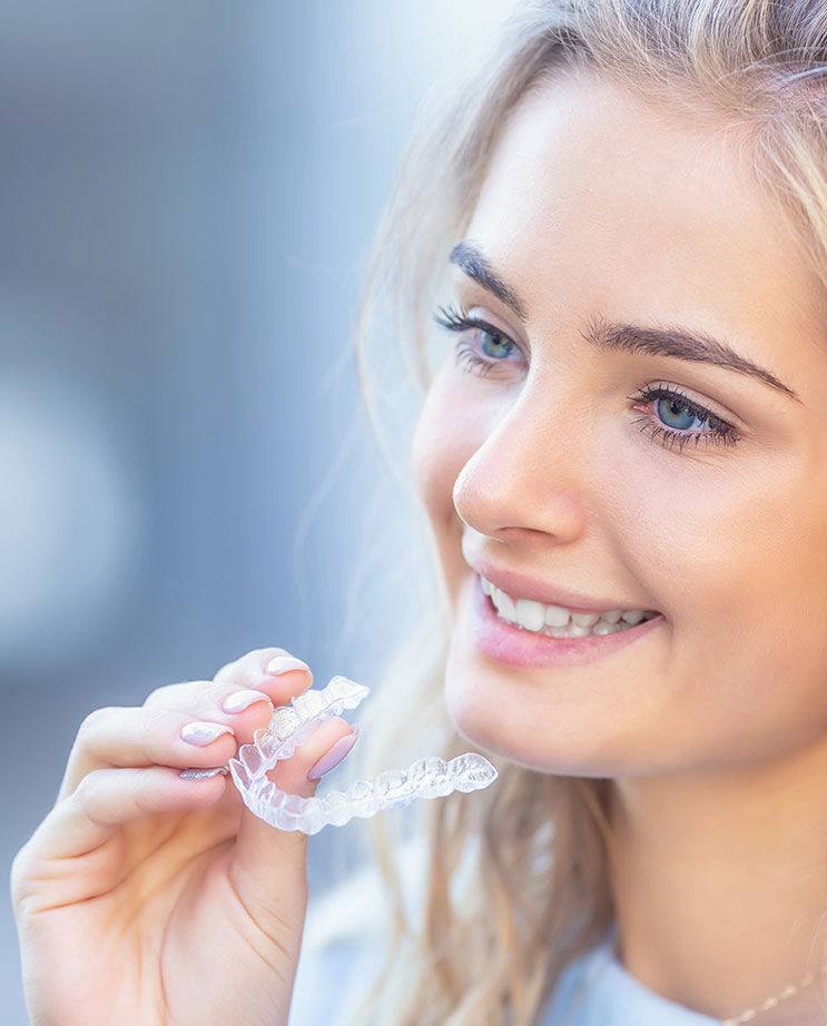 Smiling young woman with Invisalign clear aligners